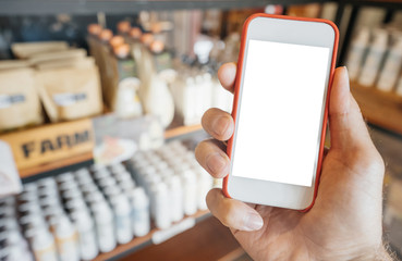 mockup, hand holding smartphone store shelves, a man buys products or makes a choice in a mobile application.