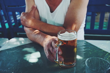 Midsection Of Man With Drink Sitting At Table