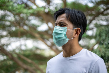 Young asian man wearing protective mask to protect against germs and air pollution , health care concept