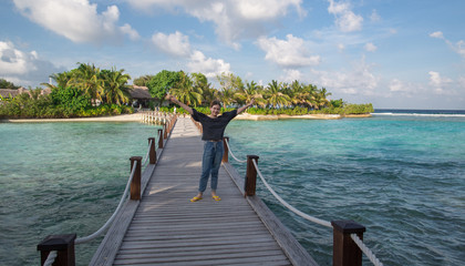 girl on the background of houses bungalows at a water resort in the Maldives