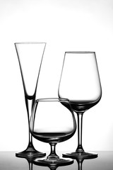 Three empty wine glasses for champagne, for whiskey, for red wine empty glassware light background