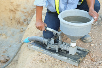 Specialist using machine grout pressure pump for grouting non-shrink concrete to precast column - obrazy, fototapety, plakaty