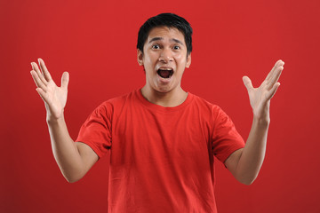 Fototapeta premium Young asian man happy and excited expressing winning gesture. Successful and celebrating