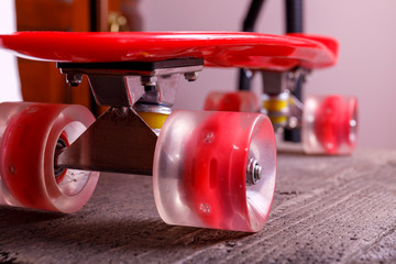 Plastic red skate board wheels close up on wooden background.