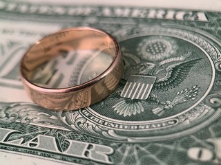The wedding ring lies on a dollar bill. Gold ring on american dollars. Concept: marriage of...