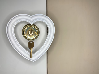 Heart on a doorknob with a key. The white heart opens with keys. Concept: closed heart.
