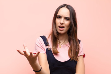 young pretty woman looking angry, annoyed and frustrated screaming wtf or what‚Äôs wrong with...