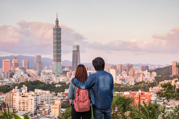 Naklejka premium Young couple traveler looking beautiful cityscape at sunset in Taipei, Travel lifestyle concept