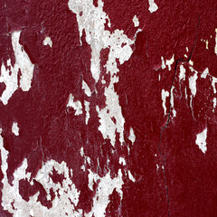 Old peeling red paint on a concrete wall.