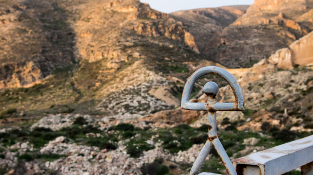 Figura de hierro sobre puente con monta&ntilde;as de fonfo