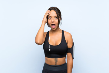 Fototapeta na wymiar Young sport girl over isolated blue background with surprise and shocked facial expression