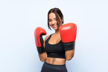 Young sport girl with boxing gloves over isolated blue background