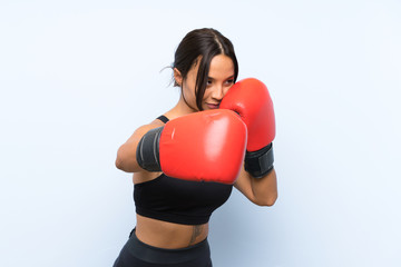 Young sport girl with boxing gloves over isolated blue background