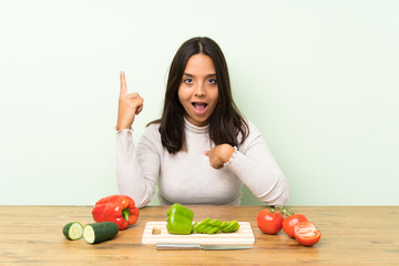 Young brunette woman with vegetables with surprise facial expression