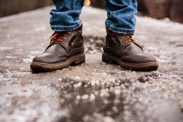 Men's winter boots on snow. Brown men's warm winter boots closeup