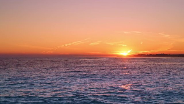 Gimbal shot of orange sunset of the ocean beach. Sunset on Marbella, Puerto Banus on Mediterranean Sea. Marbella sunset. Sunset on the beach of Costa del Sol