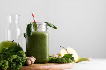 Freshly prepared jar of green smoothie, close up. Fresh vegetable smoothie on a light background....