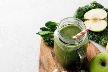 Freshly prepared jar of green smoothie, close up. Fresh vegetable smoothie on a light background. Vegetable smoothie with spinach and kale cabbage.