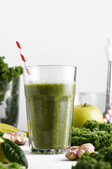 Freshly prepared glass of green smoothie, close-up. Fresh vegetable smoothie on a light background. Vegetable smoothie with spinach and kale cabbage.