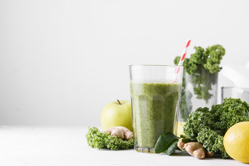 Freshly prepared glass of green smoothie, close-up. Fresh vegetable smoothie on a light background. Vegetable smoothie with spinach and kale cabbage.