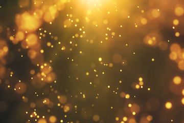 Bright golden bokeh lights background. Flying gold particles or dust. Vivid lightning. Merry...