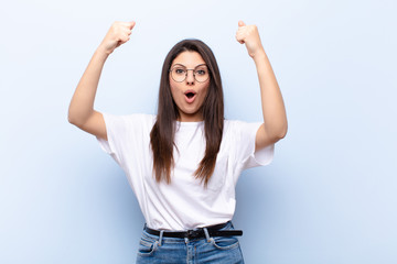 young pretty woman celebrating an unbelievable success like a winner, looking excited and happy...