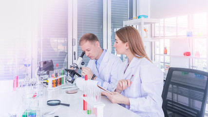 Two scientists working and discus in chemical laboratory