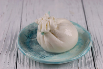Burrata cheese bag on wooden background
