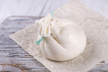 Burrata cheese bag on wooden background