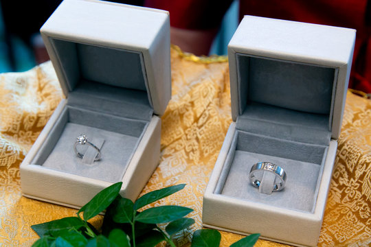 Diamond Engagement Rings with European Design in cushion boxes used in moment of exchanging (giving and receiving) rings during traditional marriage ceremony. Fine Jewelry in Wedding Ceremony Customs.