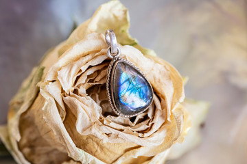 Sterling silver labradorite mineral stone pendant on rose background