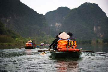 Tourist are traveling by sitting on the rowing boat in the river,  Ninh Binh, Vietnam.