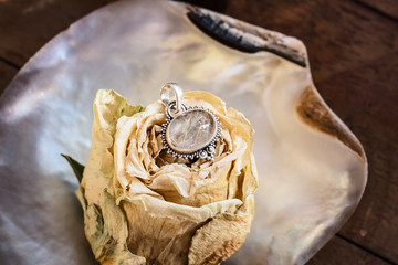 Sterling silver crystal quartz rutile mineral stone pendant on rose background