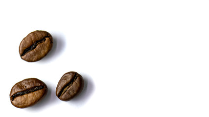 Background of three coffee beans, roasted coffee beans with selective focus on a white background, space for text.