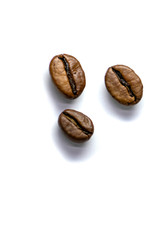 Background of three coffee beans, roasted coffee beans with selective focus on a white background, space for text.