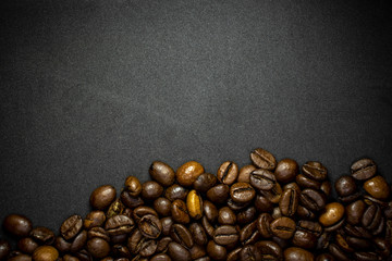 Coffee in beans on dark background. Abstract background texture.Coffee beans texture. Food background of coffee beans