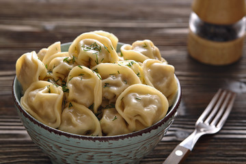 Plate of traditional Russian dumplings, ravioli on a dark wooden background.