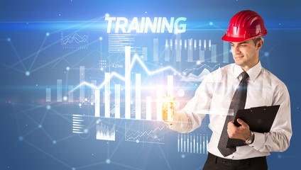 Handsome businessman with helmet drawing TRAINING inscription, architecture business plan concept