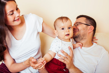 young happy modern family smiling together at home. lifestyle people concept, mother, father and little son