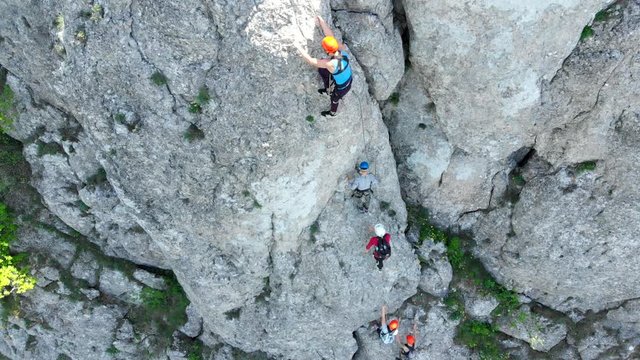 Aerial view of people climbing on rock. Summer sports and active lifestyle concept. Adrenaline, strenght, ambition. Male rock climber training outdoor in summer.