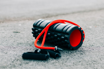 black and red sports roller and elastic band lie on the ground