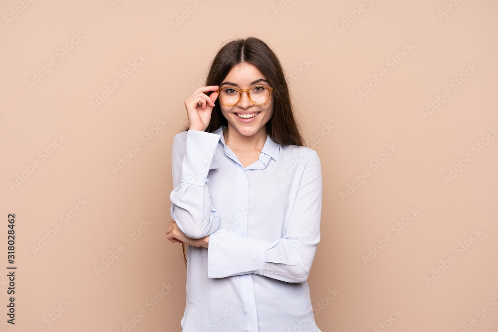 Wall mural Young woman over isolated background with glasses and happy