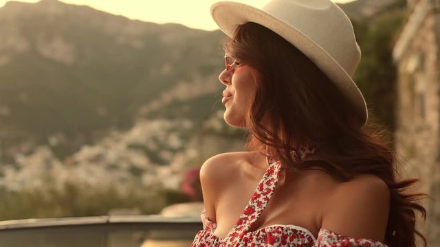 Pretty Brunette In Sunglasses And Hat. Girl Enjoys The Scenery Of Italy. Positano.