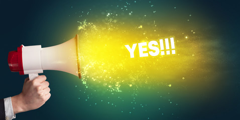 Young woman yelling to loudspeaker with YES!!! inscription, modern media concept