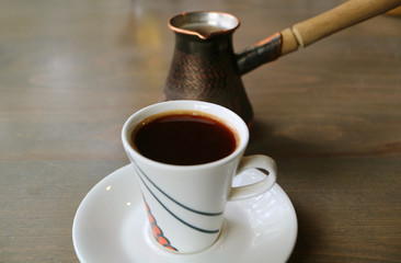 Cup of Hot Turkish Coffee with Coffee Boiler on Wooden Table