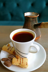 Fototapeta na wymiar Vertical Image of Hot Turkish Coffee and Butter Cookies with Blurred Coffee Boiler in Background