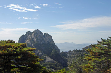Huangshan Mountain in Anhui Province, China. View of Lotus Peak from Bright Top. This is the highest peak and true summit of Huangshan. Scenic view of peaks and trees on Huangshan Mountain, China.