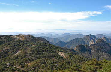 Huangshan Mountain in Anhui Province, China. View of Turtle Peak on left and other mountain peaks from Bright Top viewpoint. Scenic view of peaks and trees on Huangshan Mountain, China.