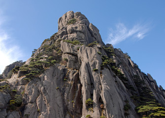 Huangshan Mountain in Anhui Province, China. The summit of Lotus Peak, the highest point of Huangshan. Scenic view of the cliffs, pine trees and summit path on Huangshan Mountain, China.