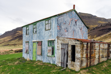Blue abandoned and rusty farmhouse. Near Djupivogur in Iceland next to the ring road during road trip. Building and architecture concept.